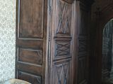 une grande armoire en bois avec un miroir, placée dans un coin