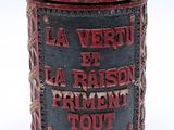 une vieille boîte en fer-blanc sur laquelle sont inscrits les mots « la vertu et la raison »