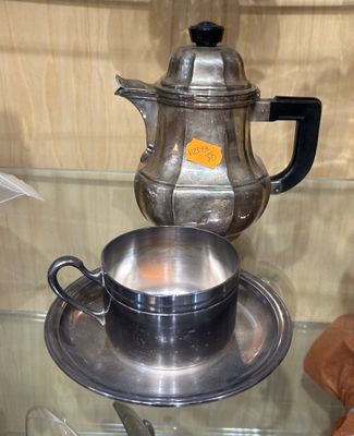 une théière en argent posée sur une table en verre