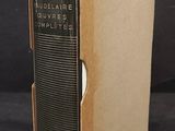 an old book sitting on top of a black table next to a black wall