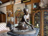 a statue of a woman sitting on top of a table