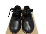 une boîte sur laquelle est posée une paire de chaussures noires