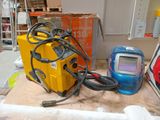 une soudeuse jaune et un casque de soudage bleu posés sur une table
