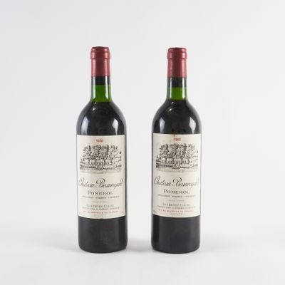 deux bouteilles de vin rouge posées l'une à côté de l'autre sur une surface blanche