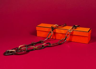 orange box with a chain attached to it on a red background