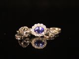 an engagement ring with a tan sapphire and diamonds on a black surface
