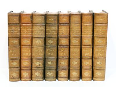 plusieurs vieux livres sont alignés sur une surface blanche