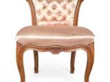 a pink chair with a wooden frame and a buttoned back