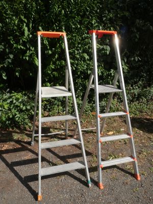 two ladders sitting next to each other on the ground