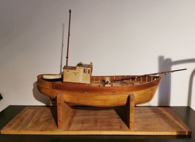 a wooden model of a boat on display on a table