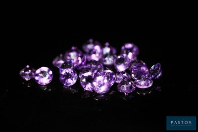 un tas d'améthystes violettes posées sur une surface noire