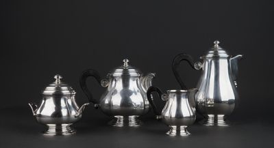 a group of silver tea and coffee pots sitting on a table