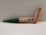 un stylo vert avec un manche en bois posé sur une surface blanche