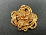 yellow gold tone flower brooch pin with a snake in the center