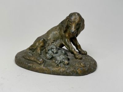 statue représentant un chien et un chat posés sur un rocher, sur fond blanc