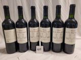 six bottles of wine are lined up in a row on a table