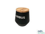 a black jar with a wooden lid on a white background