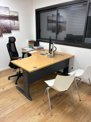 un bureau avec deux chaises et un ordinateur dessus