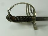 a close up of a sword on a white surface