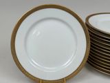 several white and gold plates stacked on top of each other