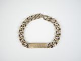 a close up of a gold bracelet with a bar on it