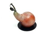 a figurine of a pear on a black plate