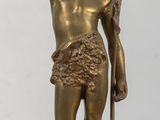 une statue en bronze représentant un homme tenant un bâton