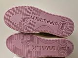 the soles of a pair of pink shoes on top of a box
