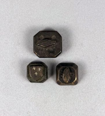 un gros plan sur trois petits objets métalliques posés sur une surface blanche