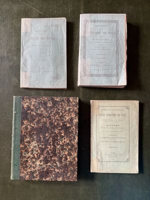 three old books sitting on top of a table next to each other