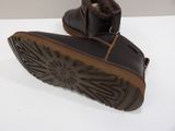 pair of children ' s brown leather boots on a white surface