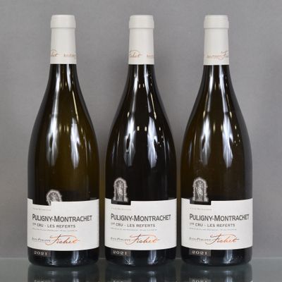 three bottles of wine are lined up on a glass table