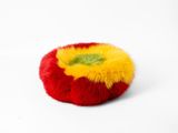 a red and yellow pom pom on a white surface