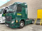 two green trucks parked next to each other in a parking lot