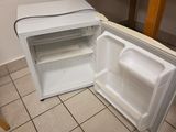 un réfrigérateur ouvert posé à même le sol dans une cuisine