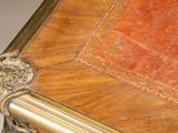 a wooden table with a red top and gold trimming