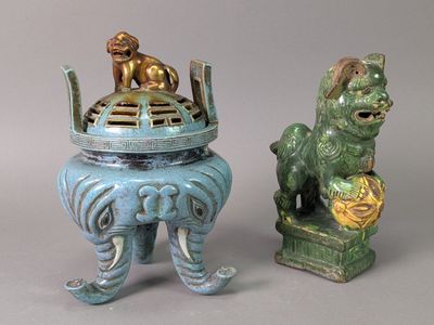 deux petites statues de lions et un lion sur un socle