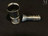 a small silver cup sitting on a black table