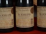 three bottles of wine sitting on a table with a red table cloth