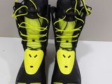 the pair of black and yellow snowboard boots are on a white table