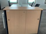 un bureau avec deux chaises et une armoire au milieu de la pièce