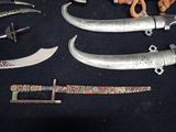 many different types of knives on a black table