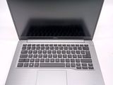 a silver laptop with a black keyboard on a white surface
