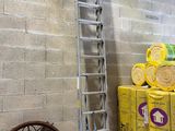 a ladder that is leaning against a wall next to a pile of boxes