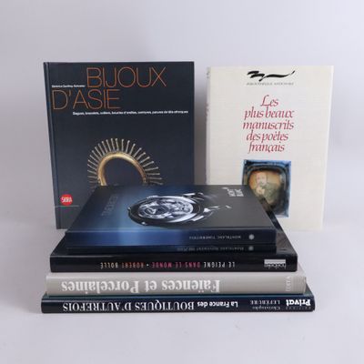 several books are stacked on top of each other on a white surface