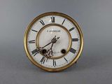 a gold clock with roman numerals on the face