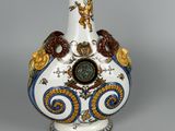 a white vase with blue and gold decorations on it