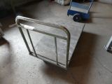 a small metal cart with a handle on the floor