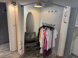 une photo d'un placard contenant des vêtements et une chaise
