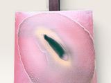 peinture abstraite rose et verte posée sur un chevalet en bois, sur fond blanc